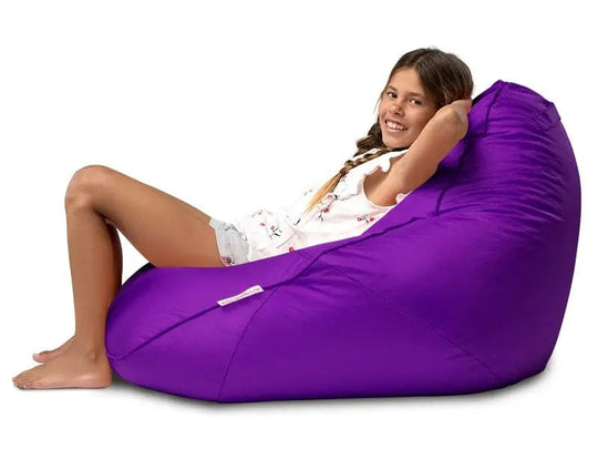 Young girl sitting on a purple bean bag chair against a white background
