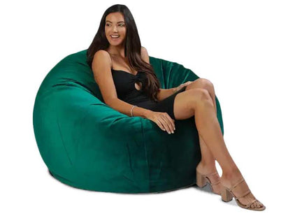 Woman sitting on a large green bean bag chair against a white background