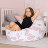 Child sitting in a bean bag with 'LOVE' prints in a bedroom setting